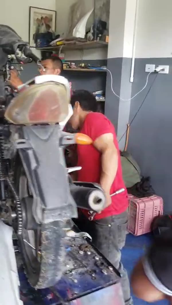 Estudiantes reparando una motocicleta en el taller